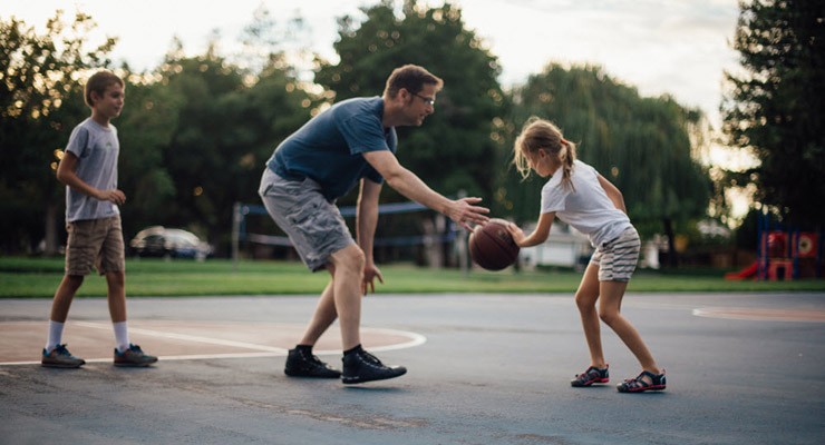0067_512774346 family playing basketball outside.