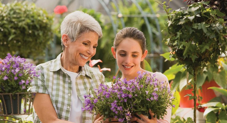 0035_80408821 woman and young girl admiring purple flower bouquet