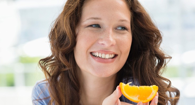 0397_177267122 woman eating wedge of orange