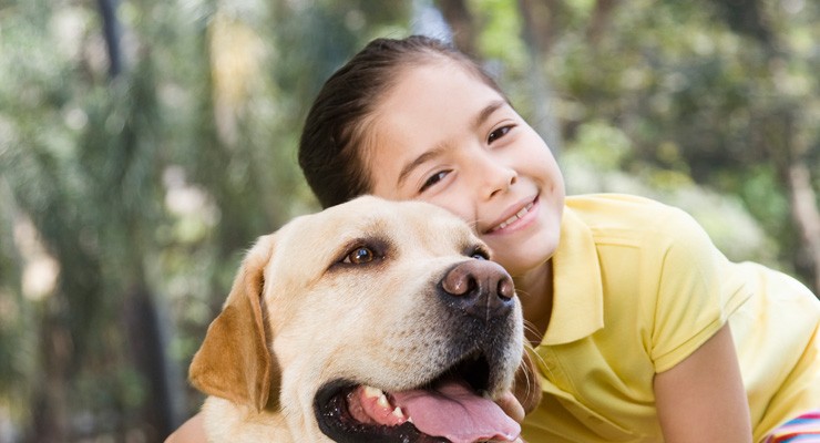 young girl hugging her dog