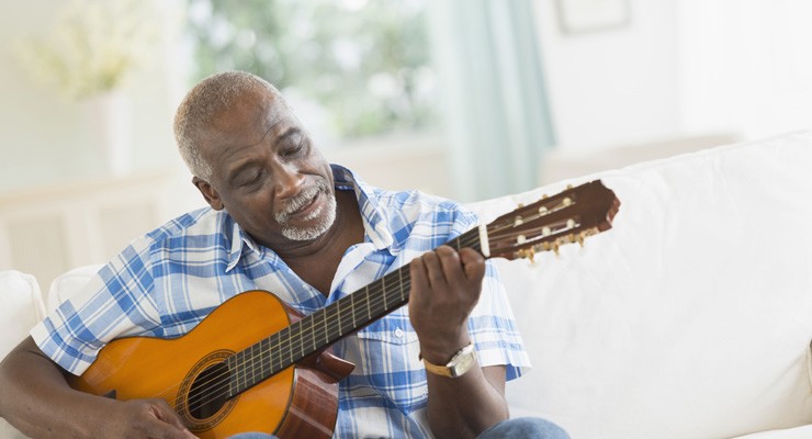 0279_470621763 man on couch playing a guitar