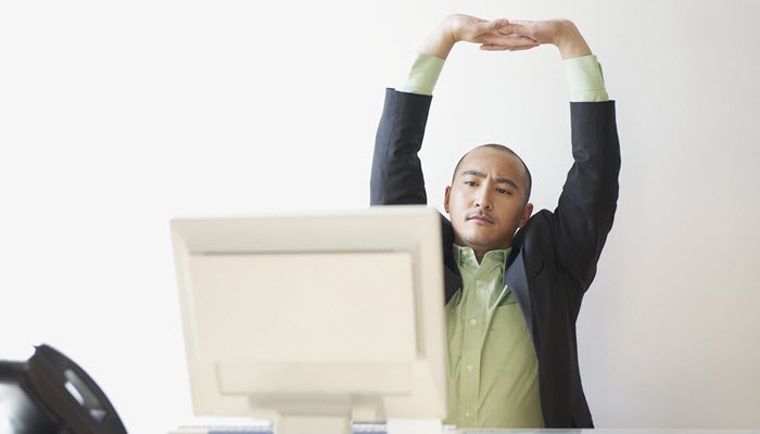 0276_523453856 man stretching at his desk