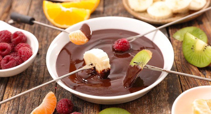 chocolate fondue with fruits bowl of melted chocolate and fruit on skewers