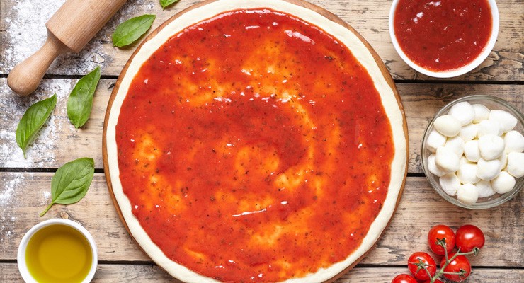 Raw dough for pizza preparation with ingredient: tomato sauce, mozzarella, tomatoes, basil, olive oil, cheese, spices served on rustic wooden table. Flat lay style. Italian pizza margheritafood pizza dough with sauce and fixings