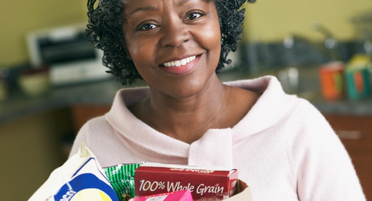 woman holding a bag of groceries in the kitchen