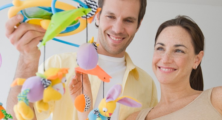 0368_82136036 pregnant woman and husband looking at baby mobile